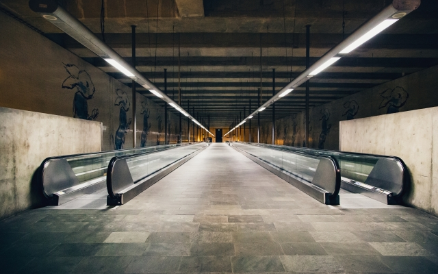 there is a long escalator in a building with a wall and floor