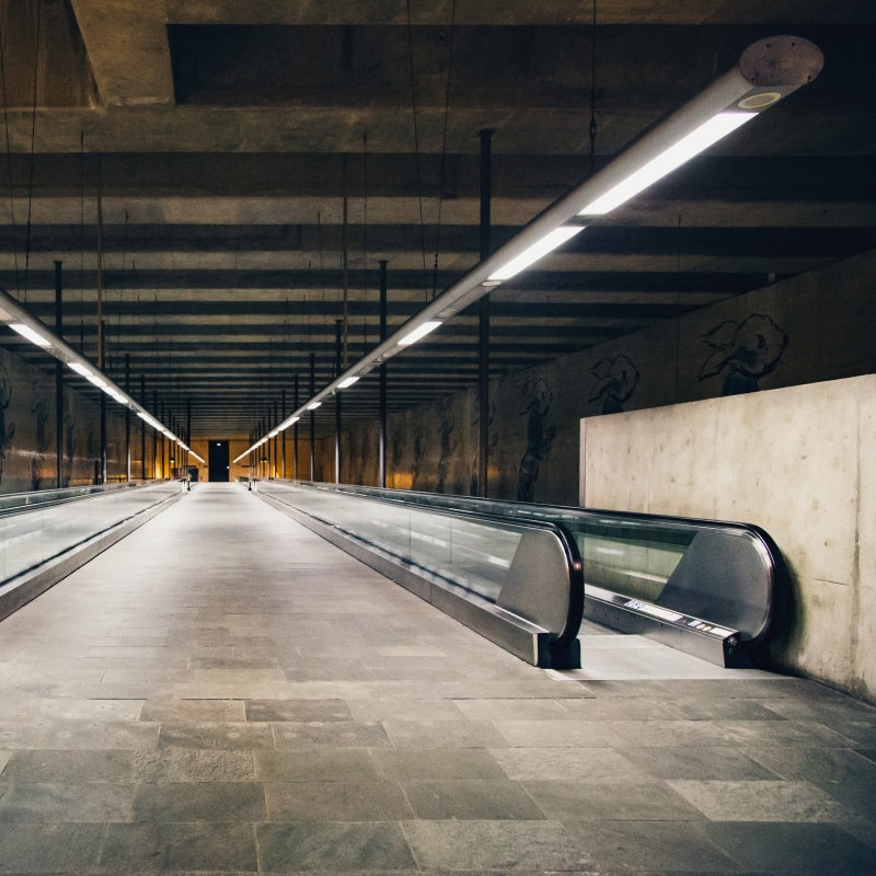 there is a long escalator in a building with a wall and floor