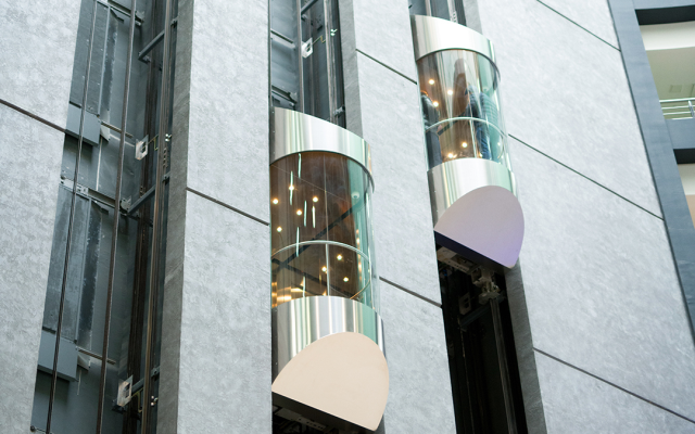 آراف هایی از ساختمان های بلند با پنجره های شیشه ای و ساعتی در بیرون