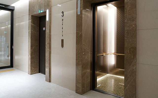 در ساختمانی با درب شیشه ای دو آسانسور وجود دارد